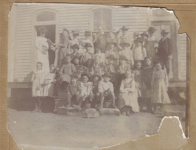 Sun City School, 1901, Barber County, Kansas. 

Teacher - middle back row - Lloyd Davis.

First Row - 2nd from left - Lyle Bullock.

First Row - 4th from left - no shoes - Cliff Hoagland, great grandfather of Kim Fowles.

2nd row:  girl standing - far left - Edith F. Hoagland (married Waldo Leffler, became mother of Elloise Leffler).

2nd row:  first girl sitting far left:  Nina Pansy Hoagland.

From Elloise Leffler's photo collection, courtesy of Kim Fowles