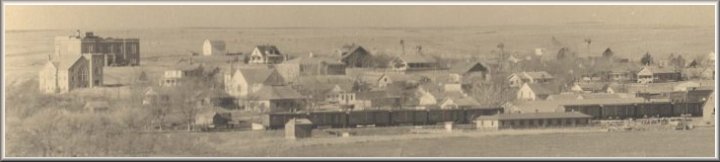 Aerial view of Wilmore, Comanche County, Ks.  The large brick building at left is now the Federated Church; behind it is the original Wilmore High School.  Photo copyright John Edward Schrock 1950